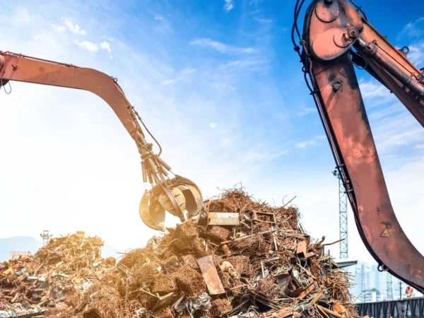 crane grab lifting scrap metal at recycling yard